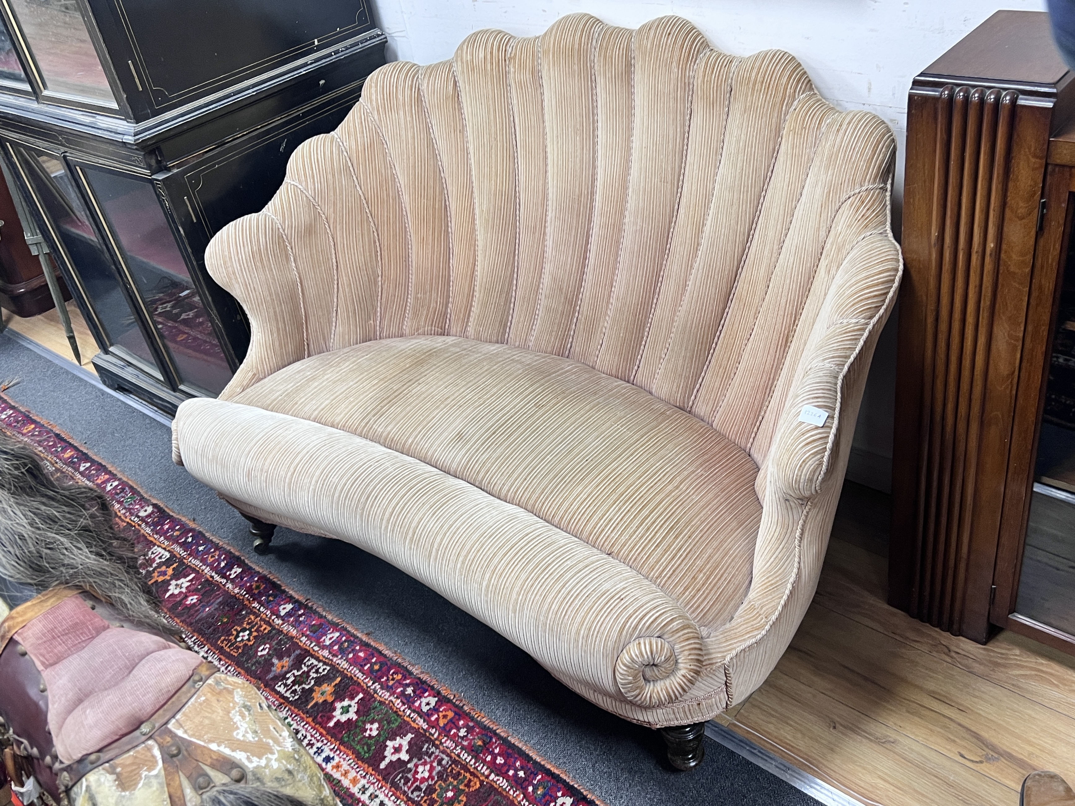 A Victorian scallop shell shaped two seater settee on turned tapered feet, length 127cm, depth 81cm, height 86cm